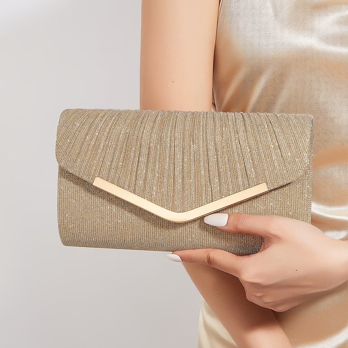 Borsa da sera color champagne con chiusura a V in metallo…